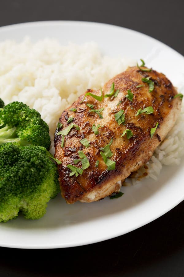 Homemade Chicken Breast, Rice and Broccoli on a White Plate on a Black ...
