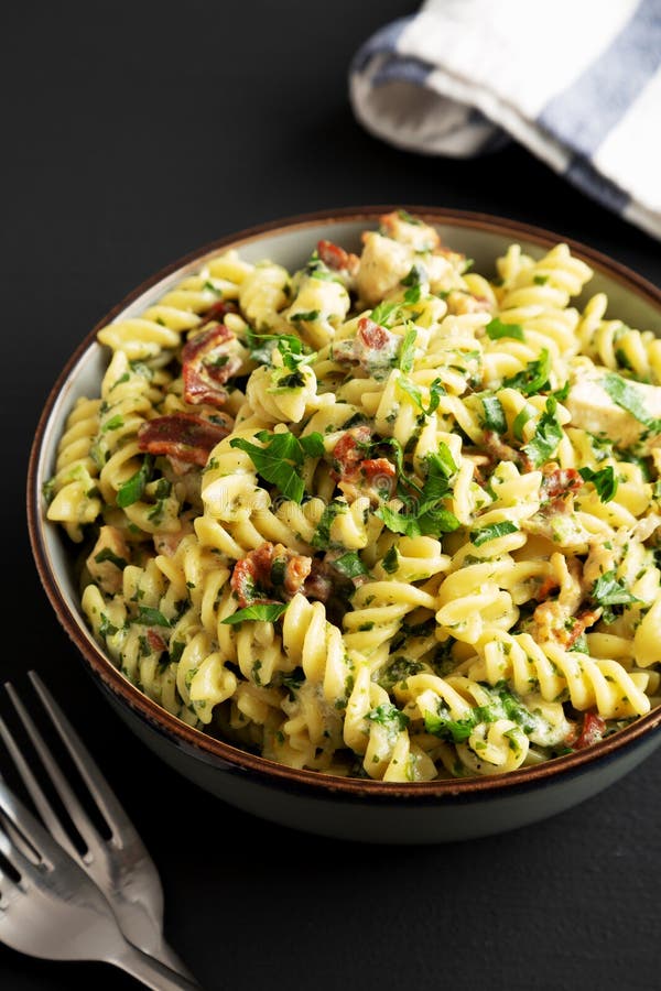 Homemade Chicken Spinach Alfredo Rotini Pasta in a Bowl on a Black