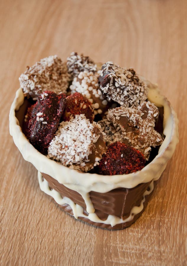 Homemade choco candies in milk chocolate basket. chocolate art figure. sweet food and calorie. Truffles with Nuts and Marzipan. royalty free stock image Homemade choco candies in milk chocolate basket. chocolate art figure. sweet food and calorie. Truffles with Nuts and Marzipan. royalty free stock image