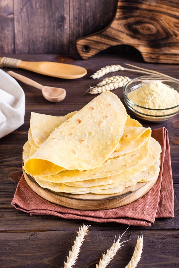 Homemade Corn Mexican Tortillas Wrap on a Board on the Table. Vertical