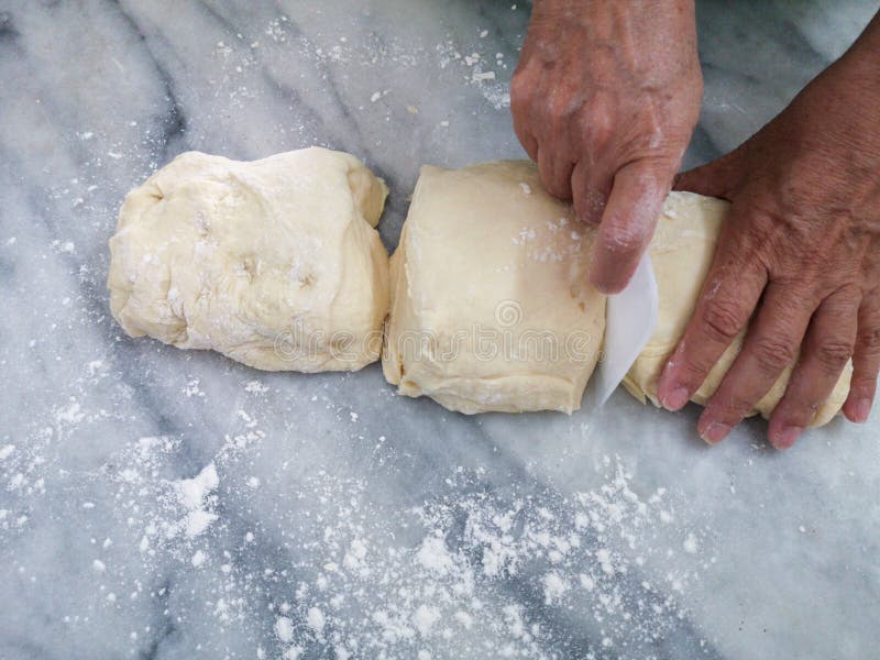 Homemade Dough. Hand Cutting Bread Dough into Pieces Stock Photo