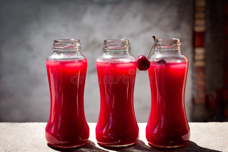 Homemade fresh cherry juice in a glass bottle