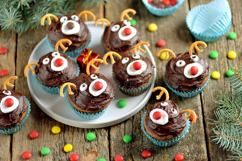 Homemade funny cupcakes Santa`s reindeers on a wooden background. Christmas idea for kids.