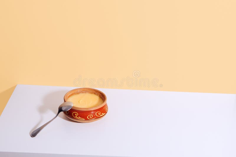 Homemade Ghee in a Ceramic Pot on a White Table. Ayurveda Stock Image