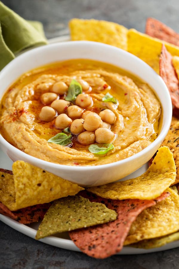 Homemade Hummus in White Bowl with Rainbow Corn Chips Stock Image