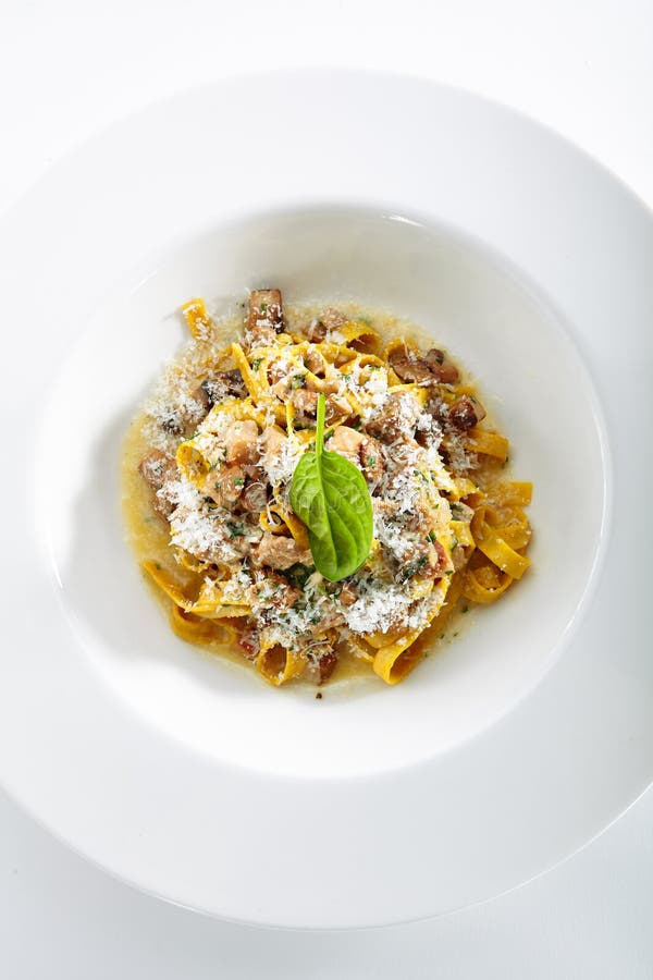 Homemade Italian Tagliatelle with Mushroom Stew and Truffles  on White Background. Restaurant Main Course with Italian Pasta, White Mushrooms, Onion, Garlic, Sauce and Parsley Top View