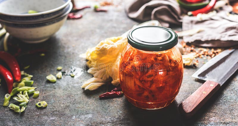 Homemade kimchi , fermented chinese cabbage marinated in hot chili sauce  in jar on rustic background with ingredients. Healthy