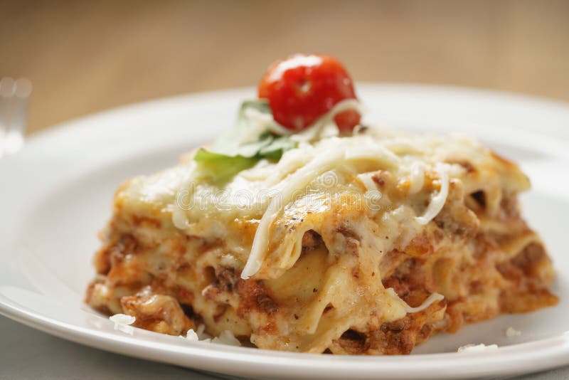 Homemade Lasagna Portion on White Plate on Wood Table Stock Photo ...