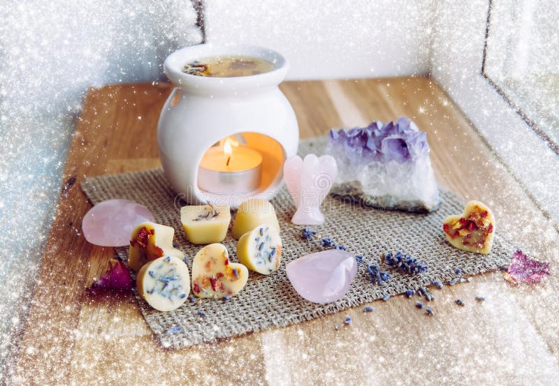 Homemade mini wax melts in aromatherapy lamp diffuser at home interior with rose quartz crystal hearts.