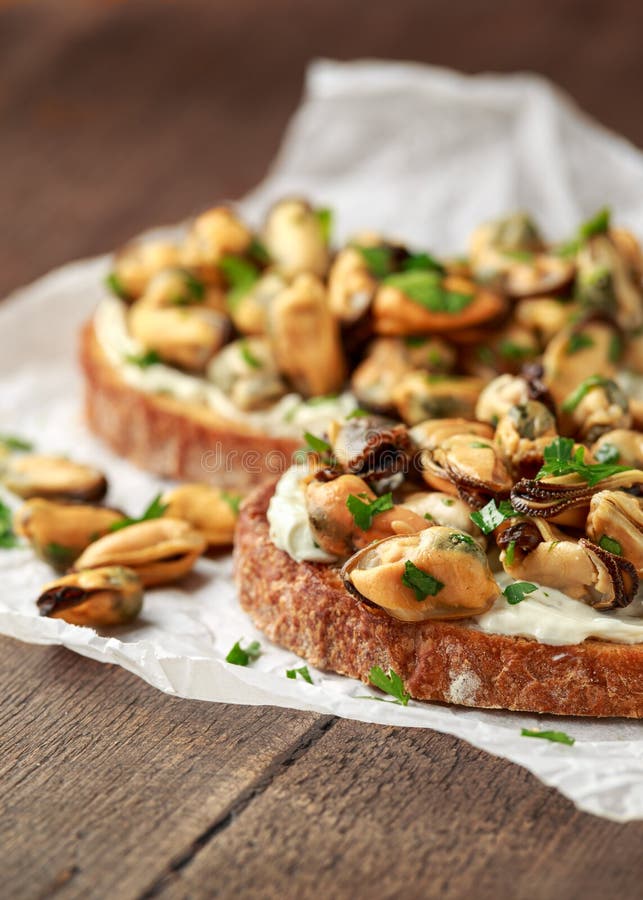 Homemade Mussels on grilled bruschetta, toast with soft cheese and herbs royalty free stock photos Homemade Mussels on grilled bruschetta, toast with soft cheese and herbs royalty free stock photos