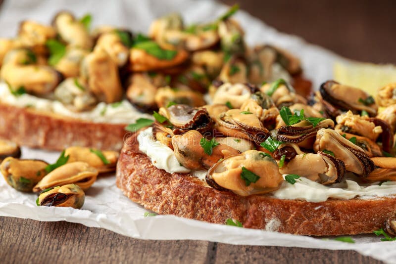Homemade Mussels on grilled bruschetta, toast with soft cheese and herbs stock images Homemade Mussels on grilled bruschetta, toast with soft cheese and herbs stock images