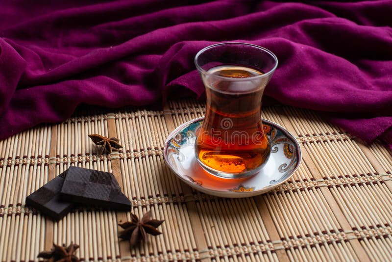 A cup of tea with chocolate on old wooden background