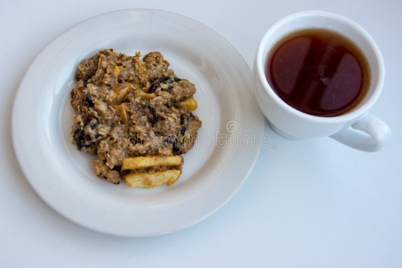 Homemade oatmeal cookies on plate with cap of tea on the white background stock image Homemade oatmeal cookies on plate with cap of tea on the white background stock image