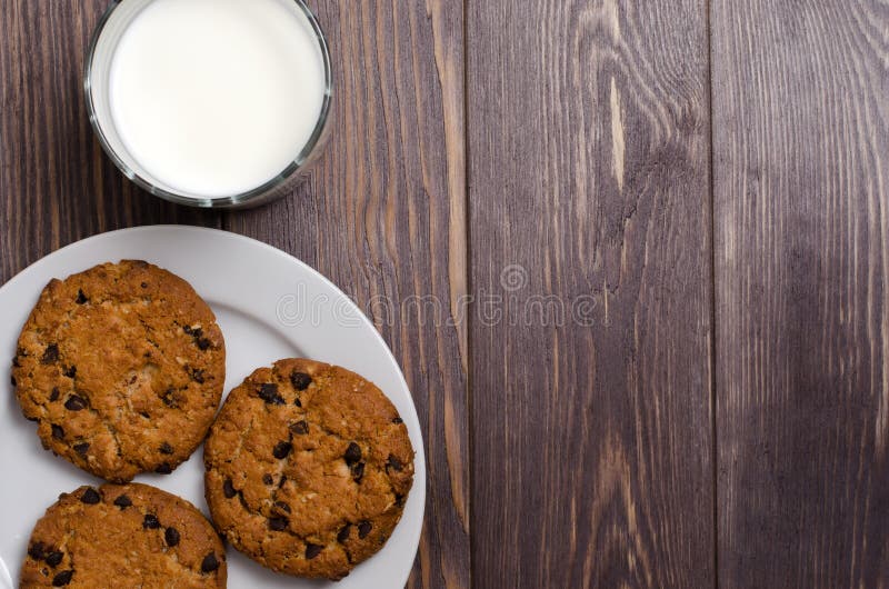Homemade oatmeal cookies on a white plate and milk. Wooden backg stock photography Homemade oatmeal cookies on a white plate and milk. Wooden backg stock photography