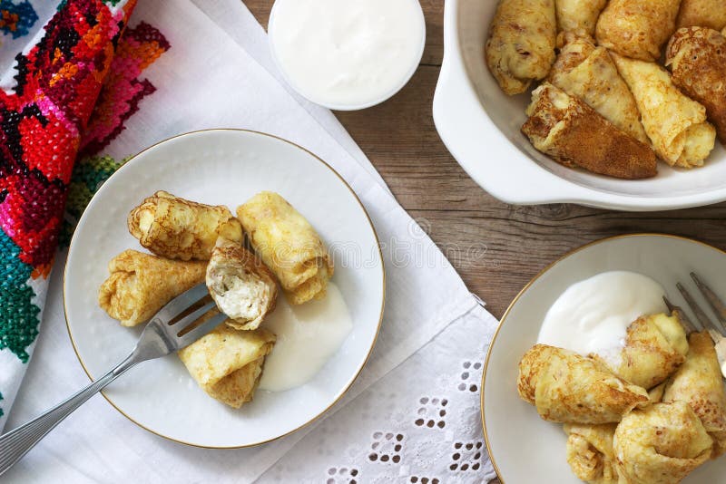 Homemade pancakes stuffed with cottage cheese with raisins, served with sour cream and cherry royalty free stock images Homemade pancakes stuffed with cottage cheese with raisins, served with sour cream and cherry royalty free stock images