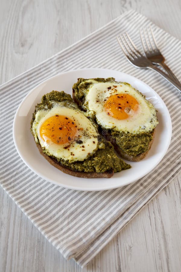 Homemade Pesto Egg Toast on a White Plate, Side View Stock Photo