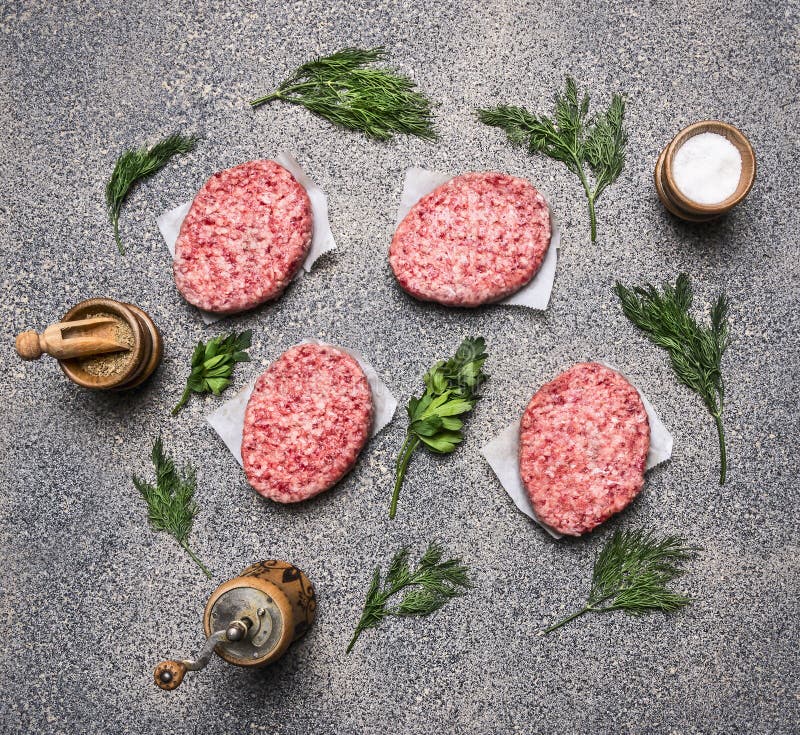 Homemade raw cutlet, on a granite kitchen counter, the concept of cooking burgers, next lined spices and herbs top view stock image Homemade raw cutlet, on a granite kitchen counter, the concept of cooking burgers, next lined spices and herbs top view stock image