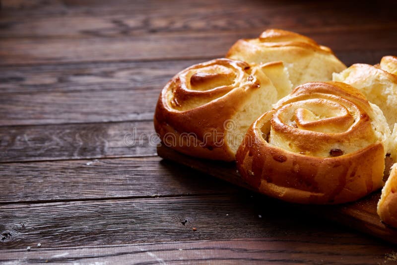 Homemade rose buns on wooden cutting board over rustic vintage background, close-up, shallow depth of field royalty free stock image Homemade rose buns on wooden cutting board over rustic vintage background, close-up, shallow depth of field royalty free stock image