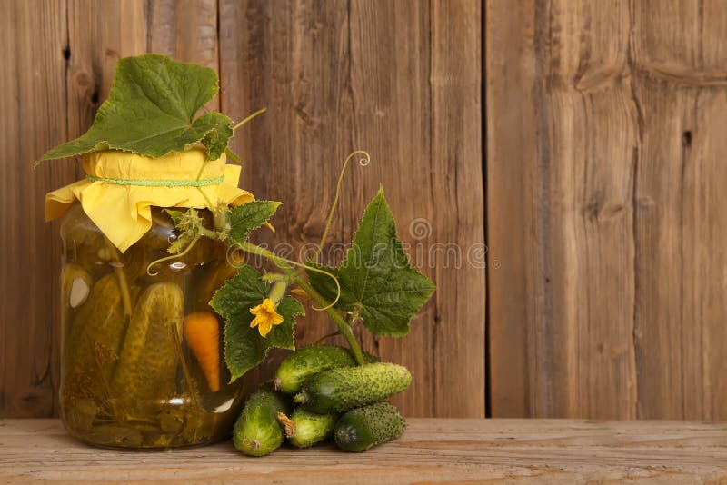 Homemade salted cucumbers in glass jar fresh cucumbers. Jar of canned cucumbers on wooden background