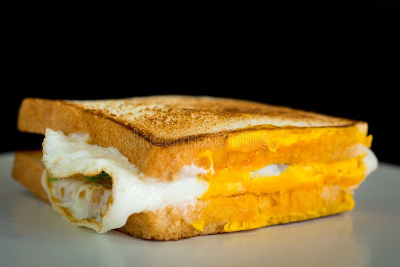 Homemade Sandwich Concept. Grill Two Bread with Fried Egg on White Plate with Copyspace Stock