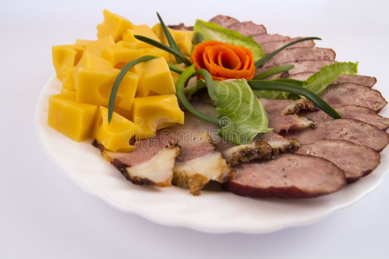 Homemade sausage, cheese and bacon laid out in a white plate on a light background royalty free stock photo Homemade sausage, cheese and bacon laid out in a white plate on a light background royalty free stock photo