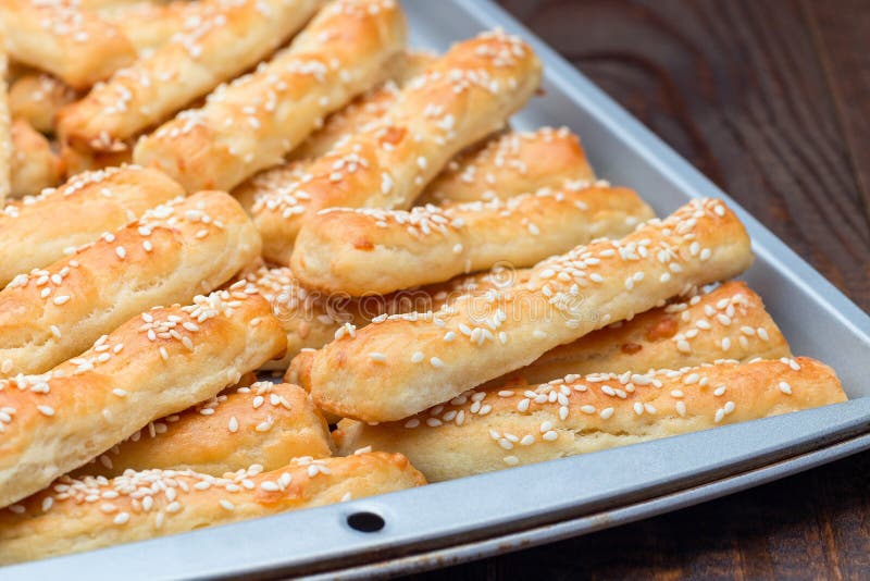 Homemade Savory Bread Sticks with Cheese and Sesame on Baking Tray