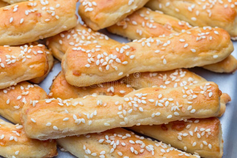 Homemade savory bread sticks with cheese and sesame on a baking tray, horizontal, closeup royalty free stock photography Homemade savory bread sticks with cheese and sesame on a baking tray, horizontal, closeup royalty free stock photography