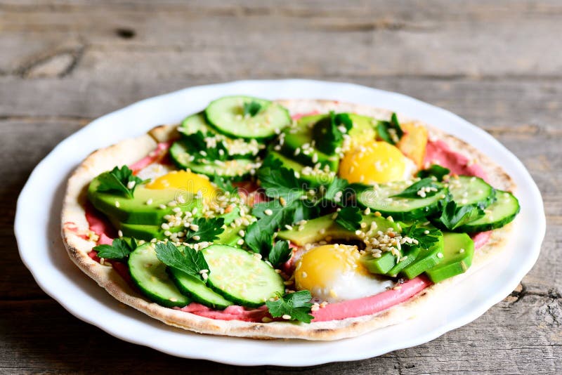 Homemade tacos with fried quail eggs, avocado, cucumber, beet hummus and parsley. Quick and easy breakfast tacos