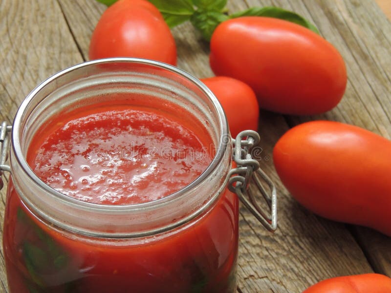 Homemade tomato souce with basil in a glass jar.