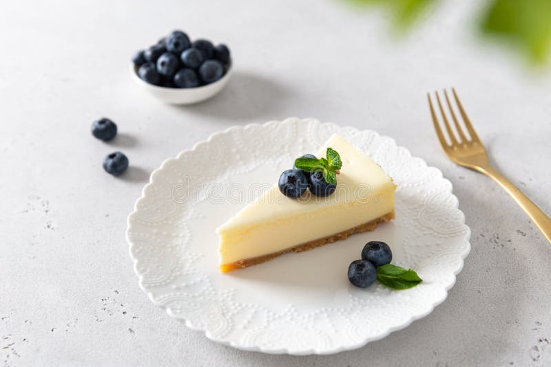 Homemade vanilla cheesecake with blueberry and mint on white background - healthy organic summer dessert pie cheesecake.