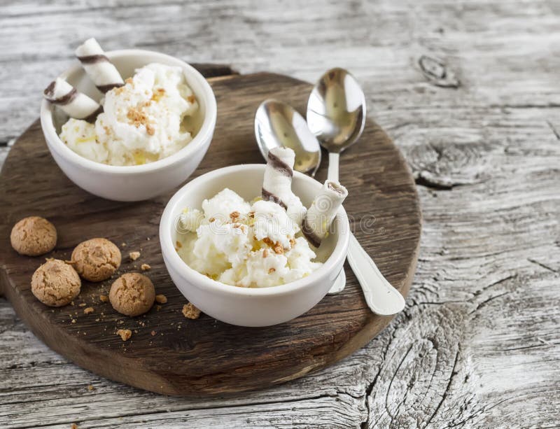 Homemade vanilla ice cream with cookies on rustic light wood background.
