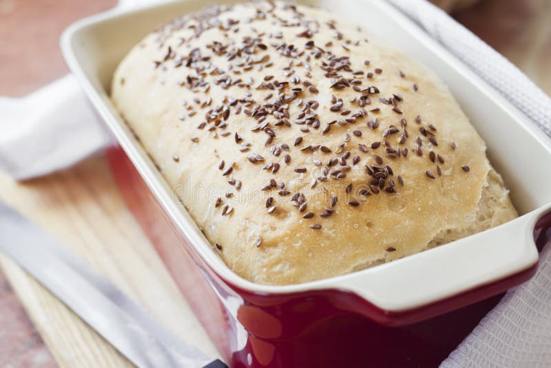 Homemade Wheat Bread with Flax Seeds in Ceramic Baking Dish Stock Photo
