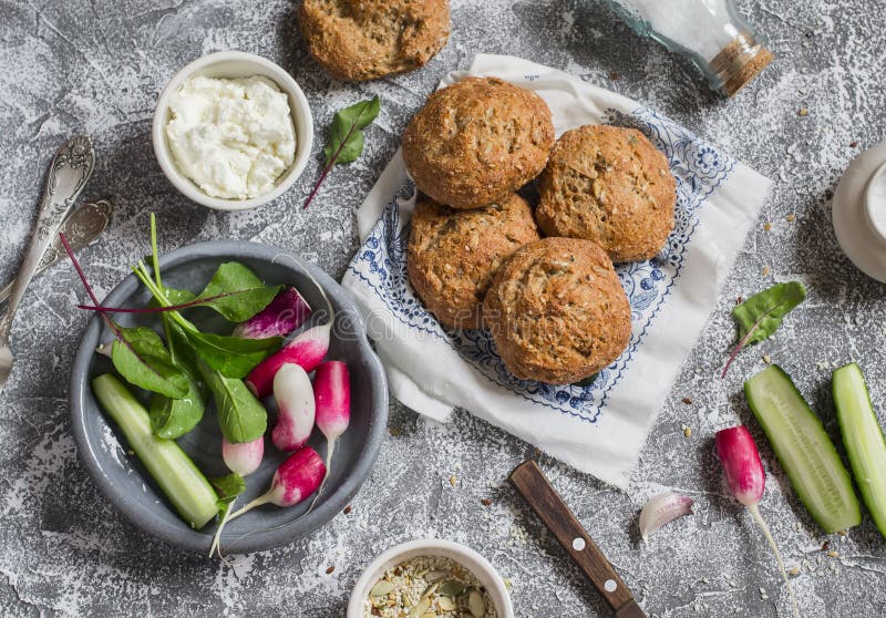 Homemade whole grain rolls, cottage cheese, fresh vegetables - radishes, cucumbers, lettuce on a grey stone background. Healthy sn royalty free stock image Homemade whole grain rolls, cottage cheese, fresh vegetables - radishes, cucumbers, lettuce on a grey stone background. Healthy sn royalty free stock image