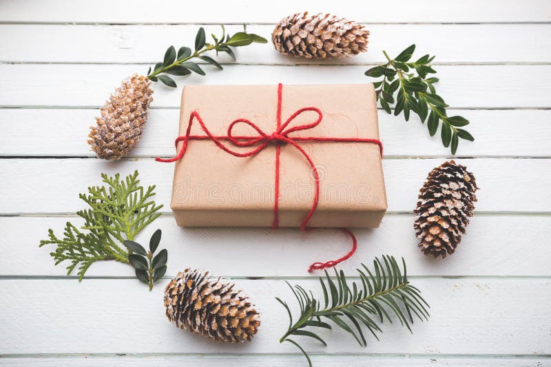 Homemade wrapped rustic brown paper packages with various natural things on white wooden surface