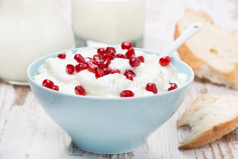 Homemade yogurt with pomegranate, milk and bread for breakfast