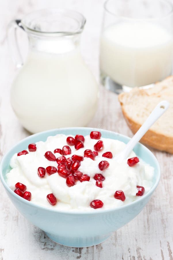 Homemade yogurt with pomegranate and milk, vertical