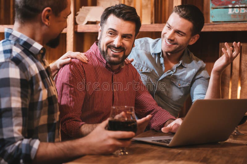 Homens agradáveis deleitados que olham seu amigo fotografia de stock Homens agradáveis deleitados que olham seu amigo fotografia de stock