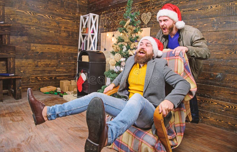 Homens animados se divertindo em casa Divertimento de Natal Você nunca ficará entediado se tiver tal amigo Passar a ano novo foto de stock Homens animados se divertindo em casa Divertimento de Natal Você nunca ficará entediado se tiver tal amigo Passar a ano novo foto de stock