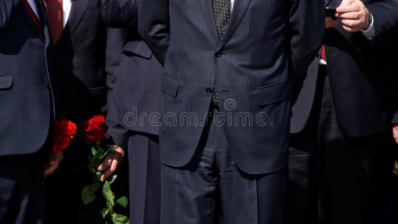 Homens em ternos pretos restritos com flores vermelhas Gest?o da empresa A delegação oficial fotos de stock Homens em ternos pretos restritos com flores vermelhas Gest?o da empresa A delegação oficial fotos de stock
