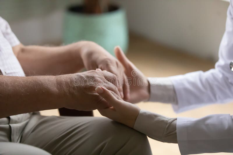 Homens idosos doentes palmas nas mãos de uma médica feminina de apoio
