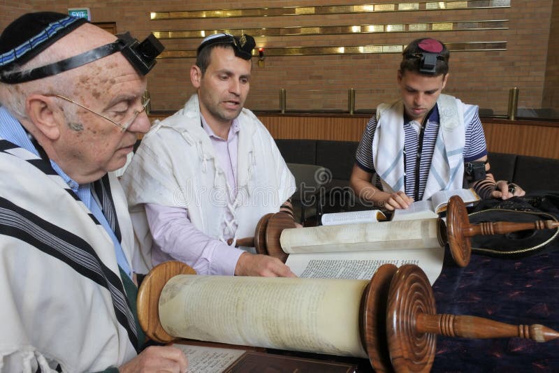 Homens judaicos que leem e que rezam de um rolo de Torah