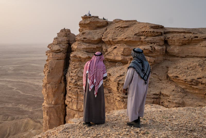 2 homens na roupa tradicional na borda do mundo perto de Riyadh em Arábia Saudita