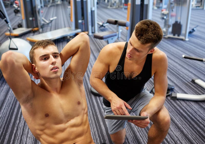 Homens que dobram os músculos abdominais no gym imagens de stock Homens que dobram os músculos abdominais no gym imagens de stock