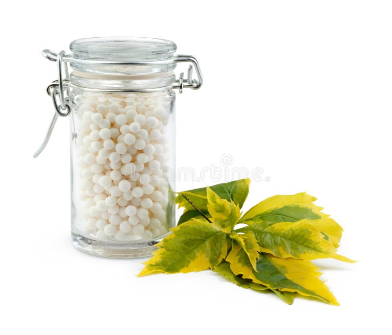 Bottle filled with homeopathy pills over white background. Green herbal drug medicine stock images, royalty-free photos and pictures