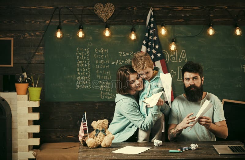 Homeschoolingsconcept Ouders die zoon het Amerikaanse tradities spelen onderwijzen Amerikaanse familie bij bureau met zoon die do royalty-vrije stock foto Homeschoolingsconcept Ouders die zoon het Amerikaanse tradities spelen onderwijzen Amerikaanse familie bij bureau met zoon die do royalty-vrije stock foto