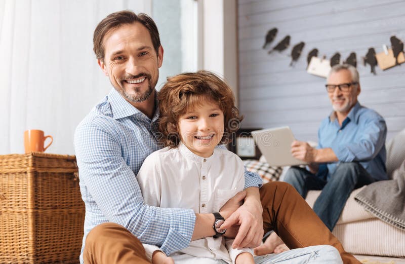 Homme agréable positif étreignant son fils images stock
