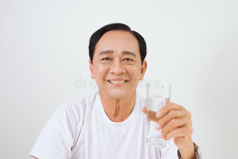 Homme asiatique supérieur tenant un verre de l'eau pure images stock Homme asiatique supérieur tenant un verre de l'eau pure images stock