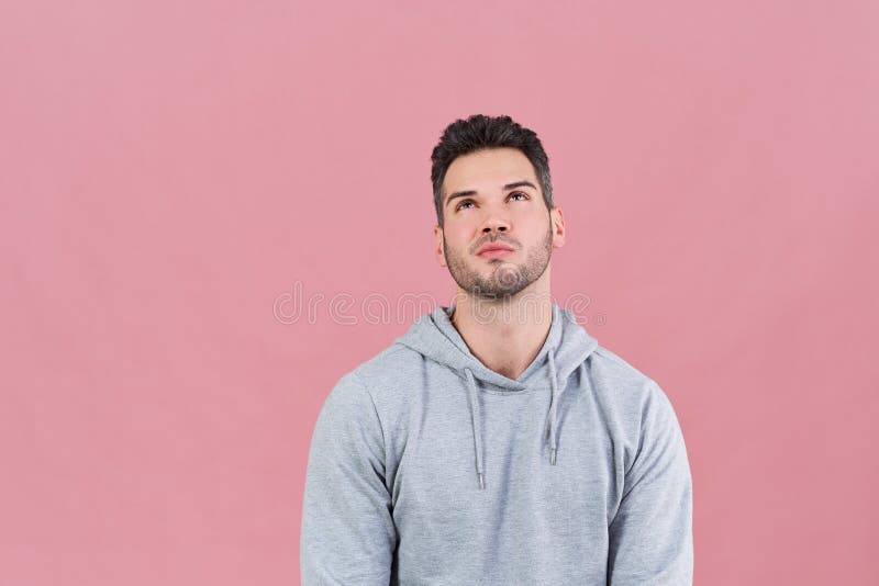 Homme attirant sportif dans un hoodie recherchant avec l'expression se rappelante pensive Concepts de choix, décision, souvenirs image libre de droits Homme attirant sportif dans un hoodie recherchant avec l'expression se rappelante pensive Concepts de choix, décision, souvenirs image libre de droits