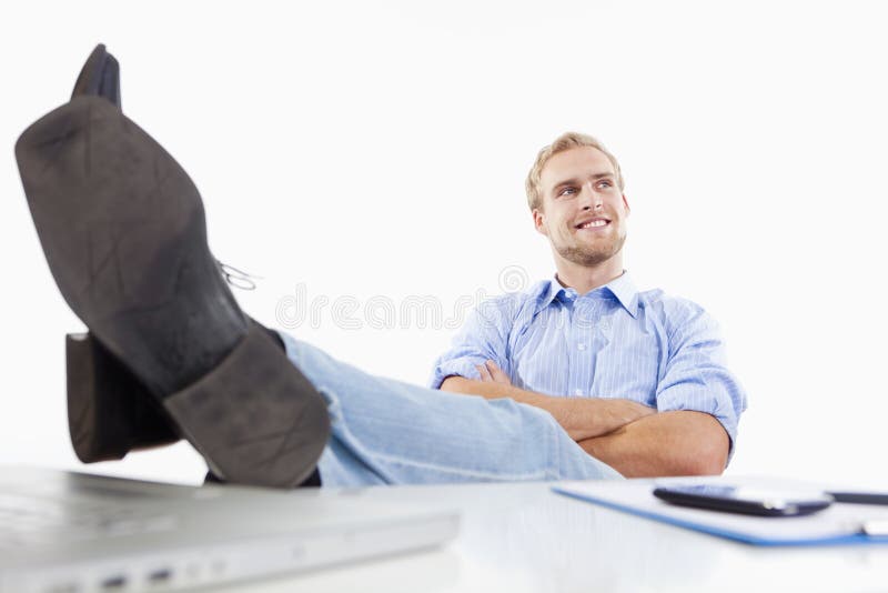 Homme au bureau avec des pieds sur le bureau photos stock Homme au bureau avec des pieds sur le bureau photos stock