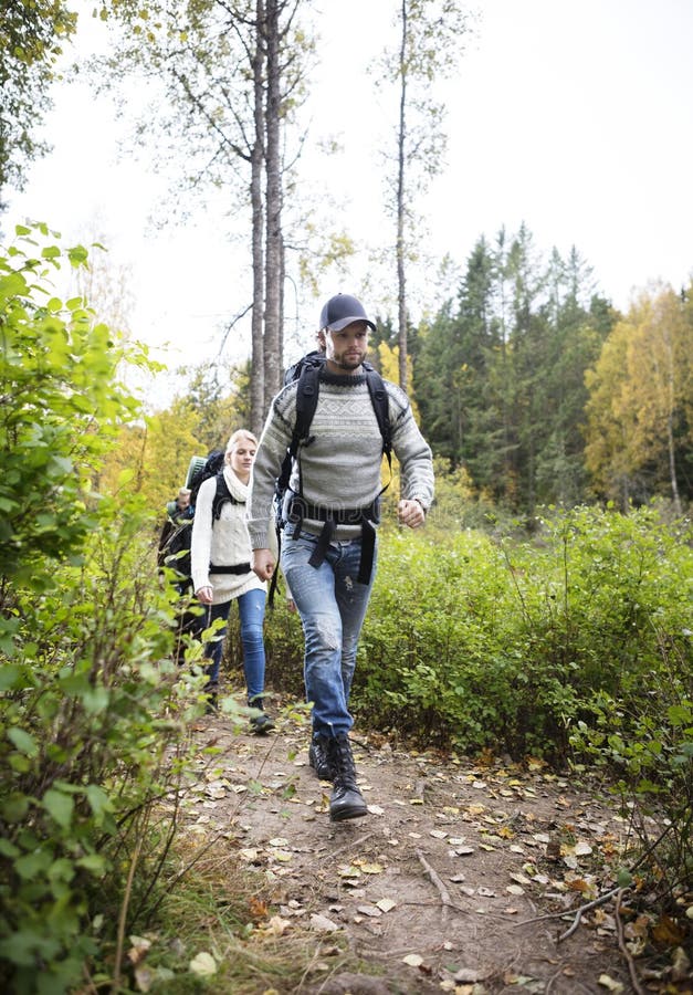 Homme avec des amis marchant sur le sentier de randonnée image libre de droits Homme avec des amis marchant sur le sentier de randonnée image libre de droits